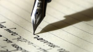 caneta escrevendo em um papel